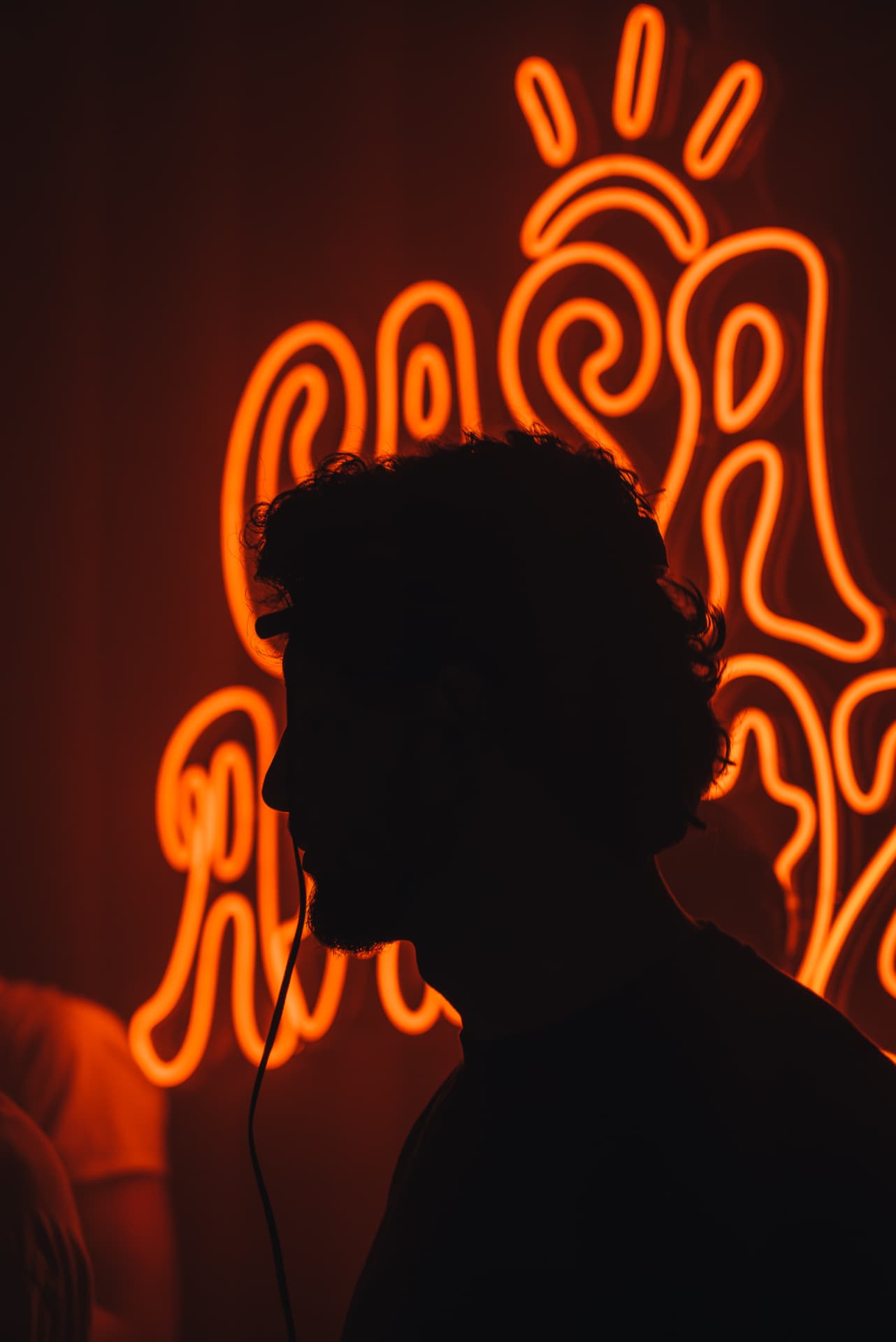 Silhouette vor dem CASA AMIGOZ Neon-Logo