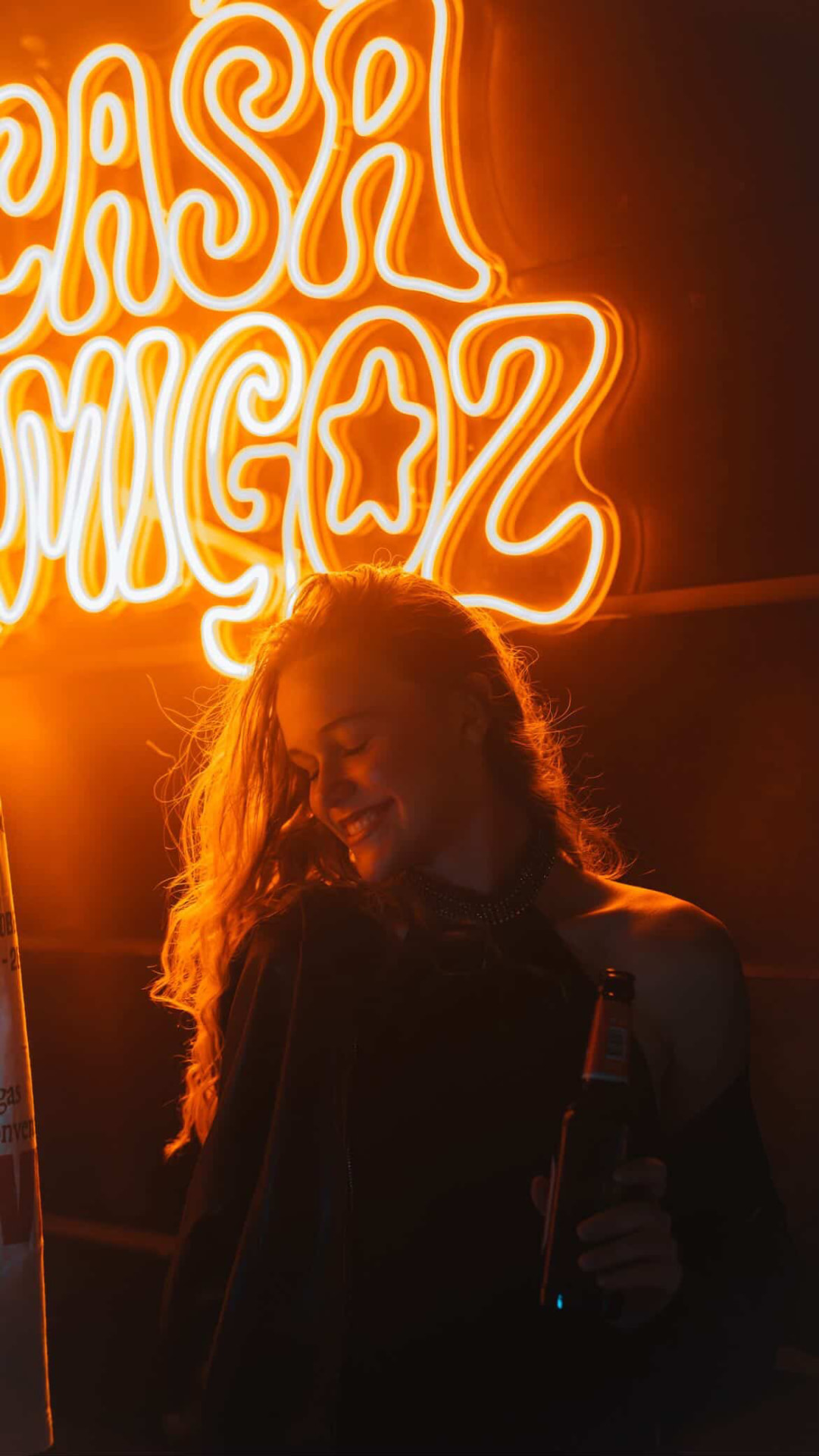 Gast vor dem CASA AMIGOZ Neon-Schriftzug
